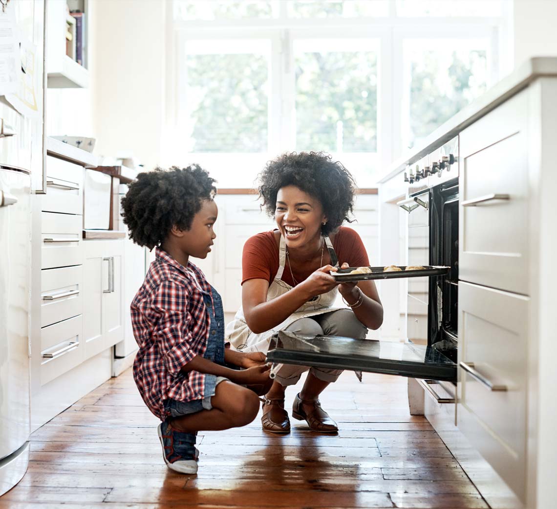 young girl and woman baking cookies in natural gas oven